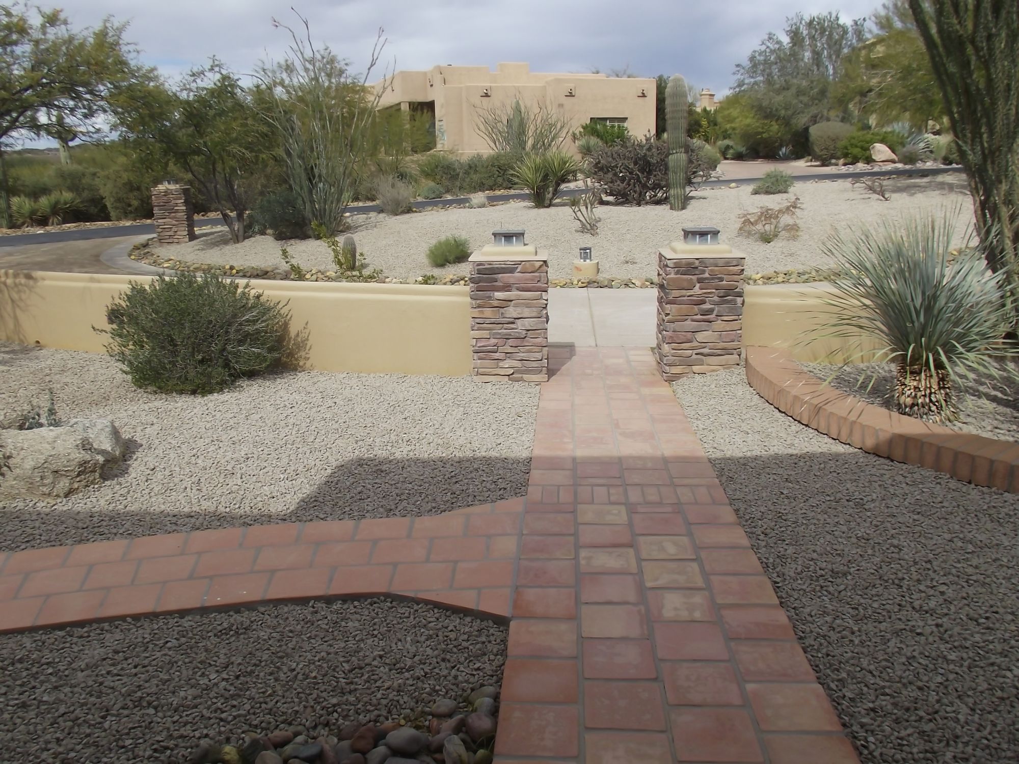 Gray decorative rock yard with a brick paver walkway at an Arizona residence