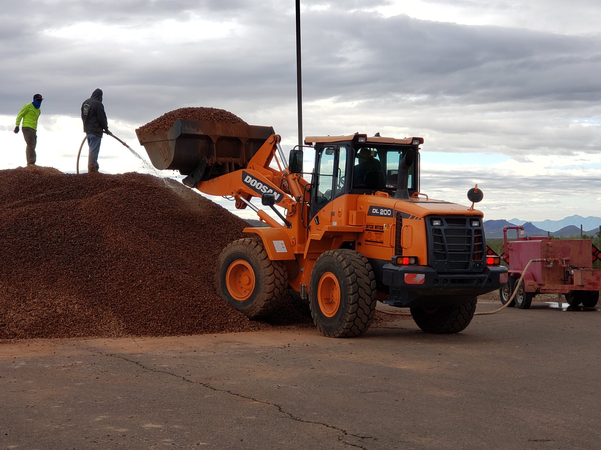 Wheel loader loading a pile of red decorative granite into a truck on an Arizona job